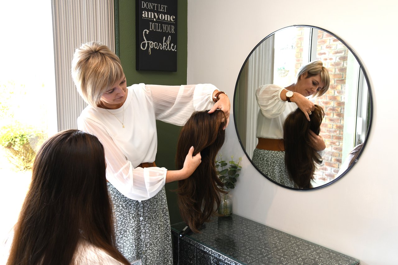 Fiona fitting a client with a wig at Hair Illusions