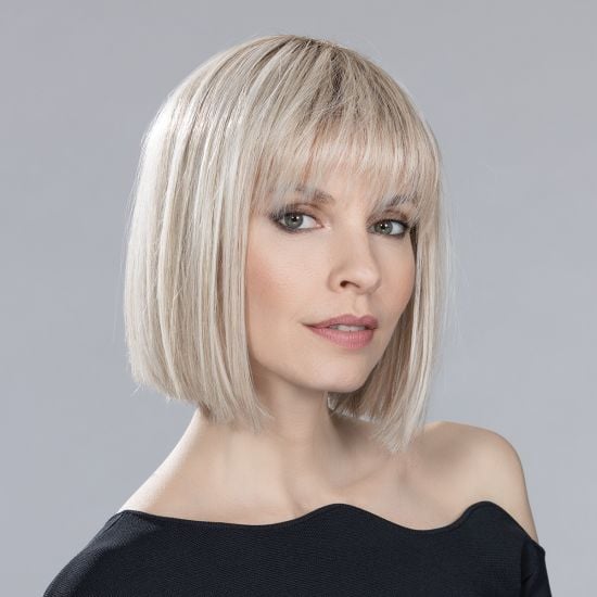 Model wearing a platinum blonde bob synthetic hair piece with fringe