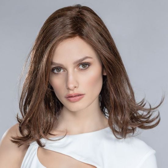 Model wearing a wavy brunette hair topper