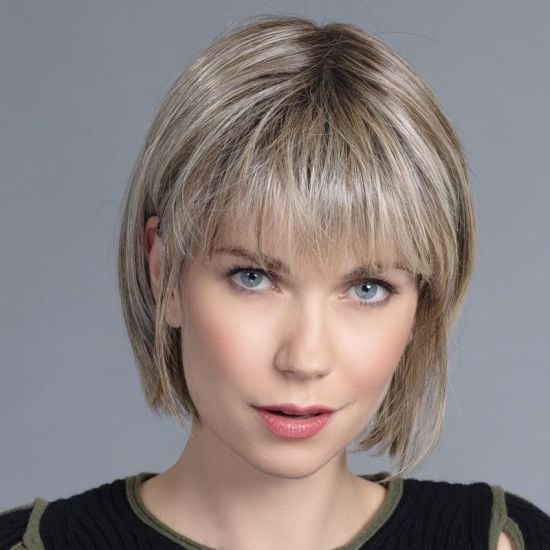 Model wearing a short blonde fringed hair topper