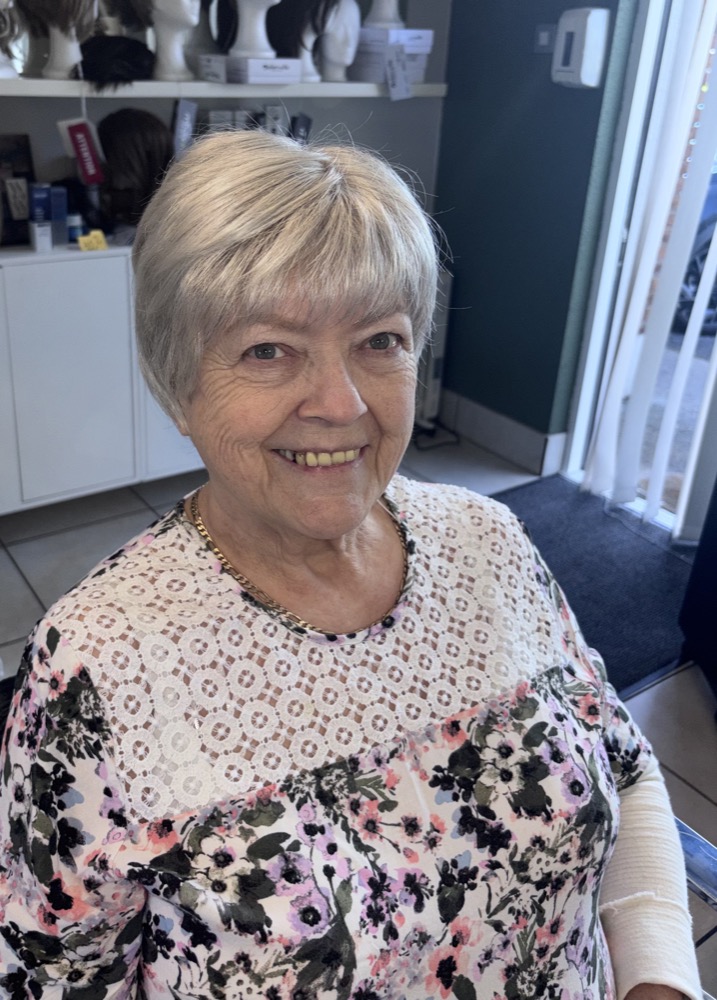 Client smiling after her wig fitting at Hair Illusions