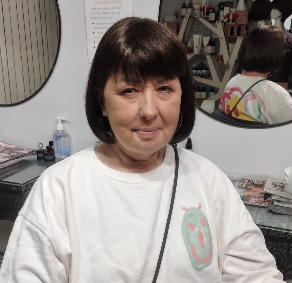 Client smiling after her wig fitting at Hair Illusions