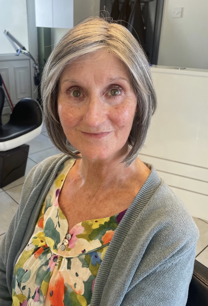 Client smiling after her wig fitting at Hair Illusions