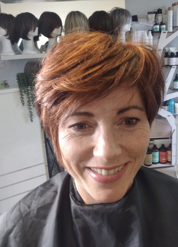 Client smiling after her wig fitting at Hair Illusions