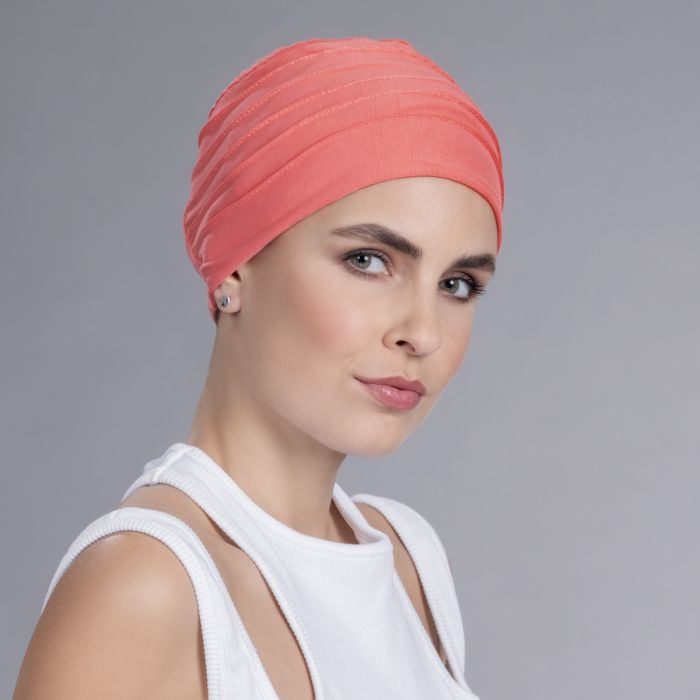 Model wearing a coral pleated turban cap