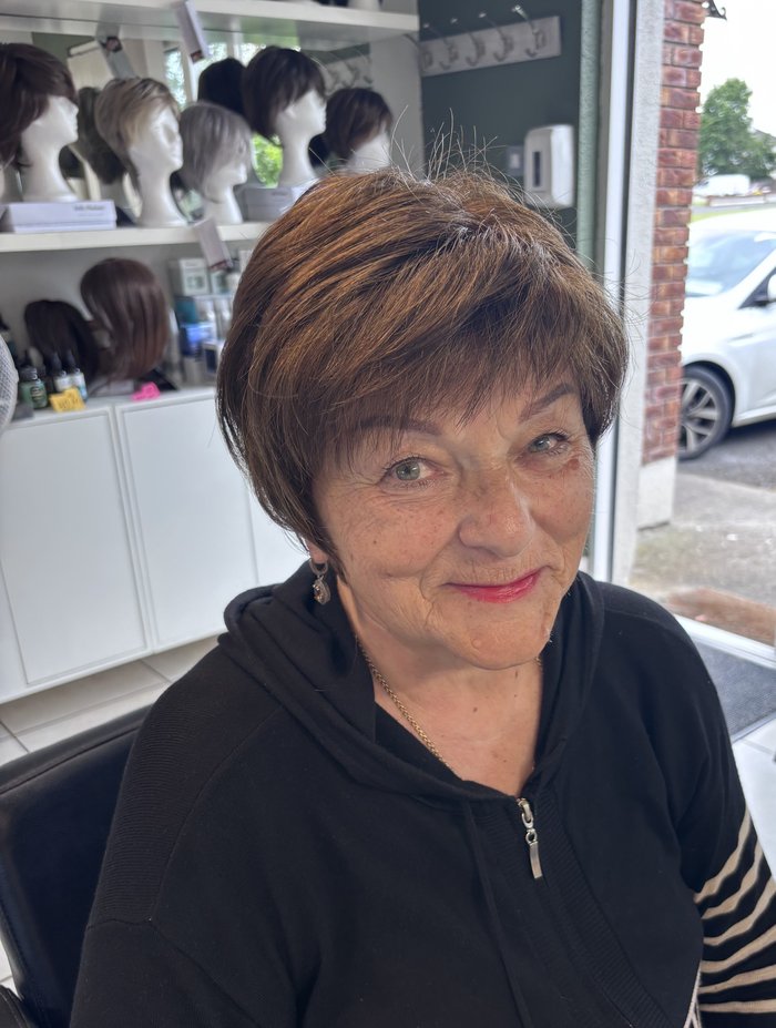 Client smiling after her wig fitting at Hair Illusions